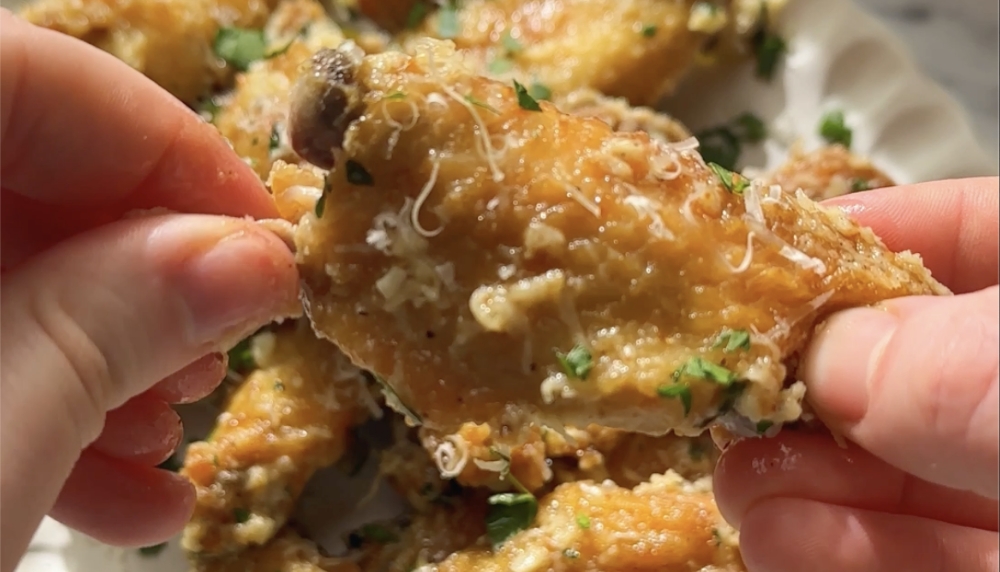 Baked chicken wings coated in parmesan cheese, and garlic