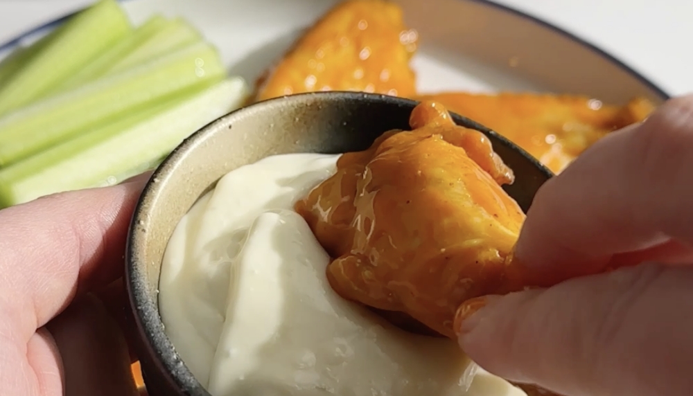 Buffalo Chicken Wing being dipped into Blue Cheese